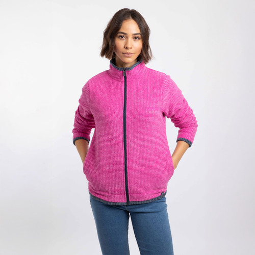 Model wearing a bright pink textured zip-up fleece with a stand collar and dark trim, hands in pockets.