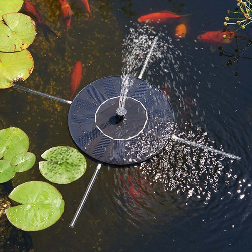 Floating solar pond fountain spraying water upward, surrounded by lily pads with orange fish swimming beneath the surface.