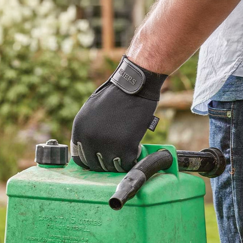 Hand wearing a black gardening glove gripping the handle of a green garden sprayer