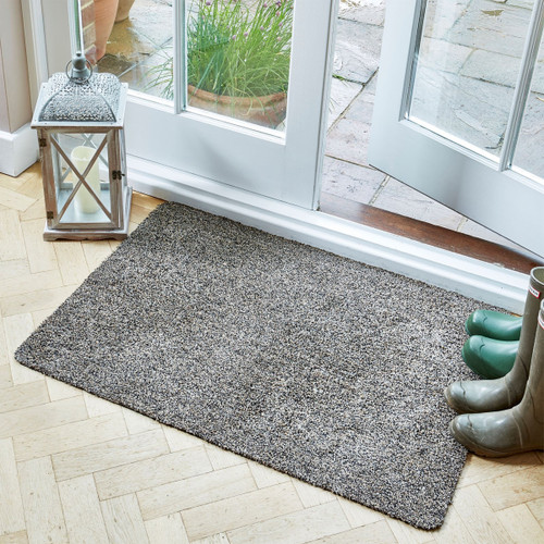 Large rectangular grey doormat placed by a glass patio door, with wellington boots and a lantern nearby.