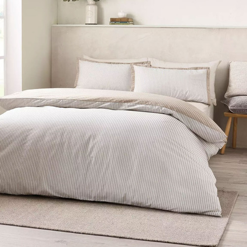 Neutral pinstripe duvet cover set in soft beige and white, styled on a double bed in a calm, modern bedroom.