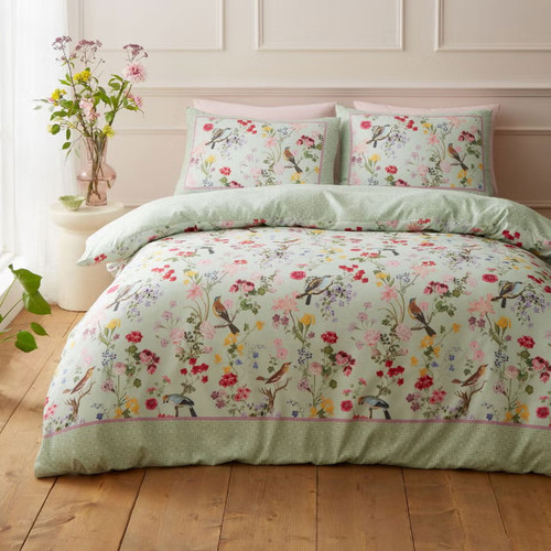 Floral bird print duvet cover set in soft pastel green, styled on a double bed in a bright, elegant bedroom.