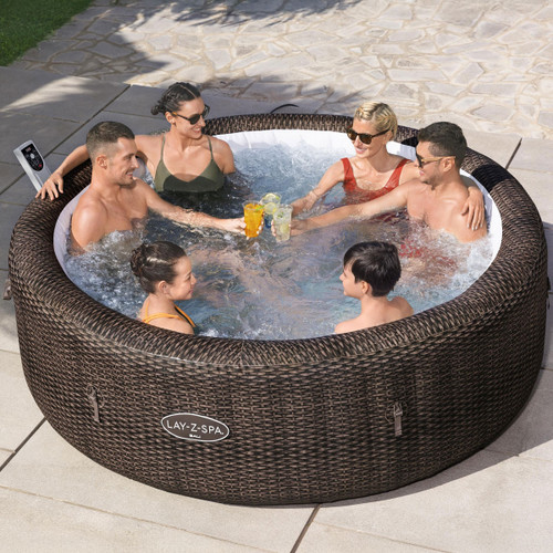 Group of adults enjoying a bubbling Lay-Z-Spa Bali inflatable hot tub on a sunny patio.