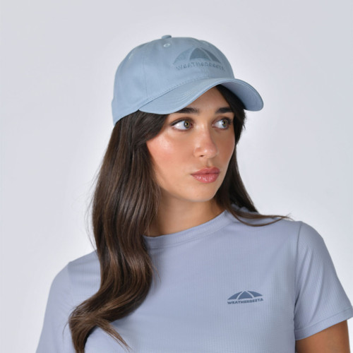 WeatherBeeta light blue baseball cap worn by model, front view close-up