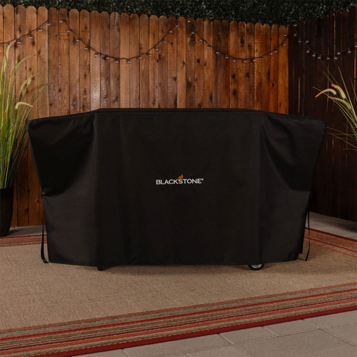 Blackstone griddle cover fitted over outdoor griddle in garden setting