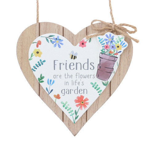 Wooden heart-shaped hanging plaque with a white heart panel reading “Friends are the flowers in life’s garden,” decorated with colorful flowers, a bee, and a small illustration of a flower pot, finished with a twine hanger and bow.