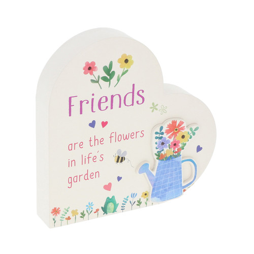 Freestanding heart-shaped plaque with the message “Friends are the flowers in life’s garden”, decorated with colourful flowers, a bee, small heart motifs, a frog and a blue watering can filled with flowers.