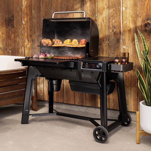 Traeger Woodridge pellet grill cooking ribs, chicken and vegetables on patio