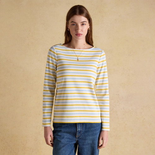 Woman wearing a long sleeve Breton top with yellow and light blue stripes, front view.