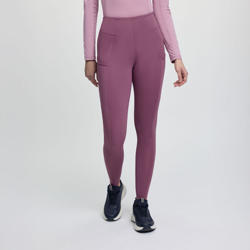 A person in pink leggings and a matching long-sleeve top stands mid-step. They wear dark sneakers. The background is a light, neutral color.