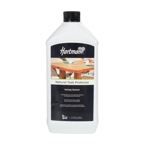 White plastic bottle of Hartman “Natural Teak Protector – Honey brown” with a black cap and black label featuring an image of a wooden outdoor dining table. The label states it helps maintain the natural teak colour and that the bottle is made from 100% recycled HDPE.