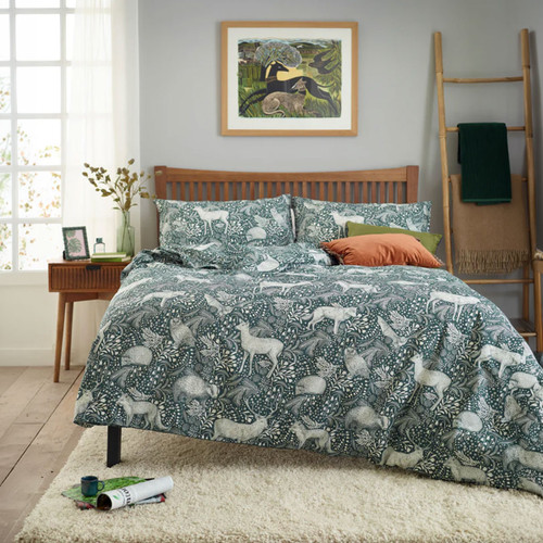 Green woodland animal duvet cover set on double bed, featuring deer, rabbits and botanical foliage print, modern bedroom styling with wooden bed frame, soft rug and decorative cushions