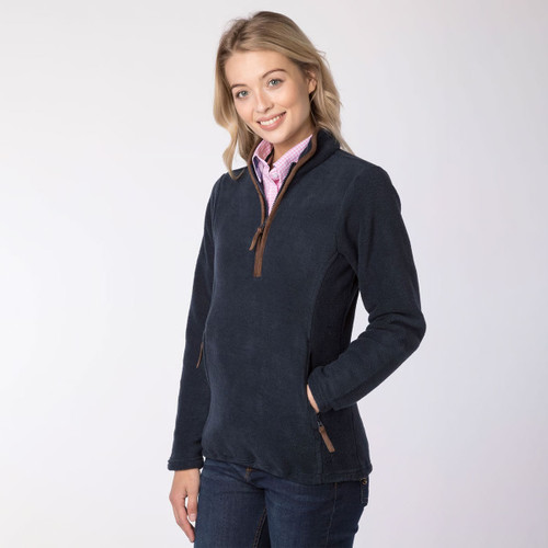 Woman wearing an ink blue overhead fleece with brown trim over a pink checked shirt, shown from the front.