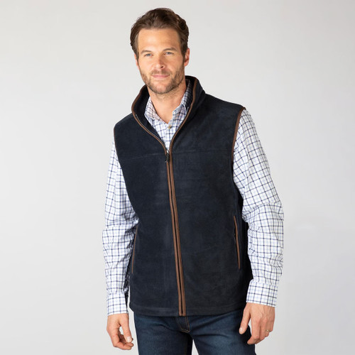 Mid-length front view of the model wearing the navy fleece gilet over a checked shirt.