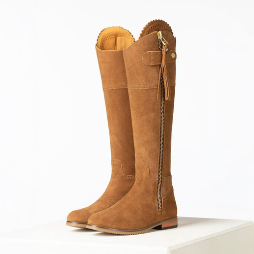 Pair of tan suede knee-high country boots with side zip, tassel detail and low heel, front angled view.