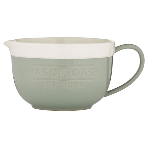 Mason Cash mixing bowl with handle and pouring spout in soft green and cream ceramic, embossed “MASON CASH EST 1800” text, kitchen batter bowl isolated on white background