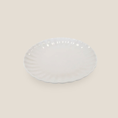 Cream ceramic plate with scalloped rim, front view.