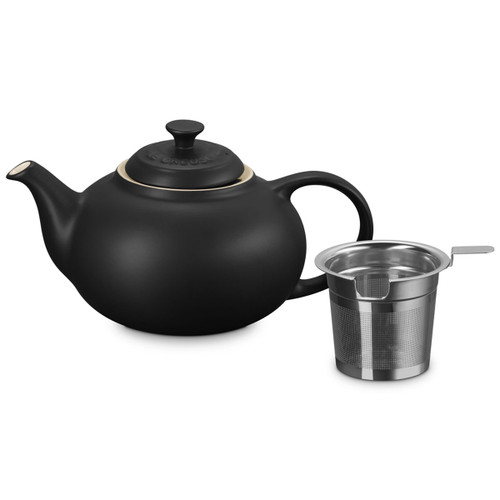 Black ceramic teapot with lid and removable stainless steel infuser on a plain background