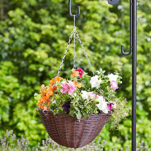 Brown wicker hanging basket planter filled with colourful flowers, suspended from a garden hook outdoors