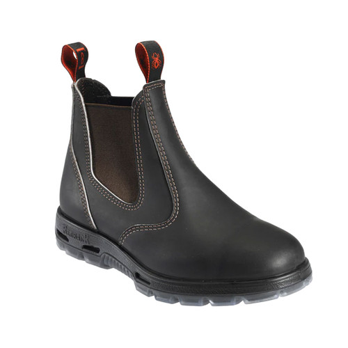 Brown Redback Chelsea safety boot with brown elastic side panels, red pull tabs and a chunky translucent sole, shown from a side angle.