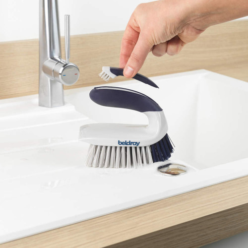 Beldray Scrape and Scrub cleaning brush being used to clean a kitchen sink, featuring an integrated detail brush for hard-to-reach areas.
