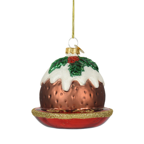 Hand-painted glass Christmas pudding ornament with white icing, green holly leaves and red berry detail, displayed on a red plate with gold glitter trim and hanging loop.
