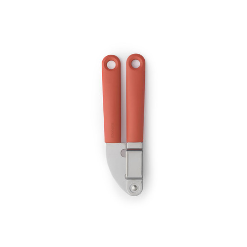 Brabantia Tasty+ garlic press with coral handles and grey body, shown closed against a light grey background.