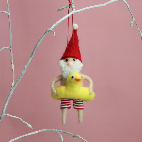 Felt Santa Christmas hanging decoration wearing red striped swim shorts and a yellow duck inflatable ring, displayed on a decorative branch.