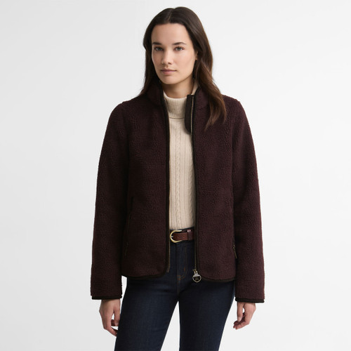 Model wearing the Barbour women's borg fleece jacket in a rich burgundy colour with a full zip fastening and stand collar.