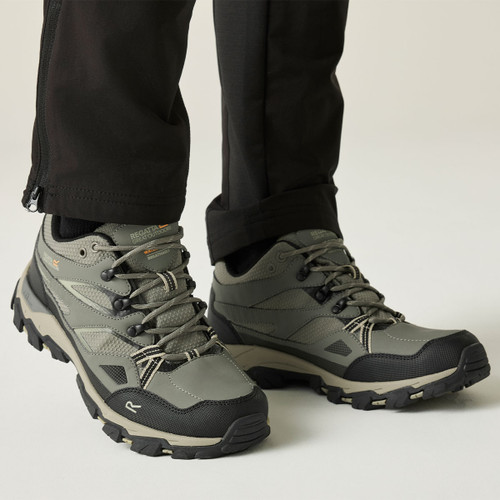 Person wearing grey waterproof hiking shoes with rugged grip soles, demonstrating a supportive low-cut fit for hiking and outdoor walking.
