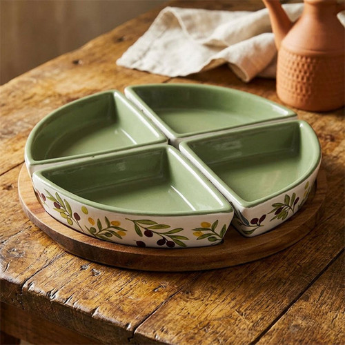 Four-piece ceramic snack dish set with a round wooden serving tray, featuring a colourful olive branch design and soft green glazed interior, displayed on a rustic wooden table.