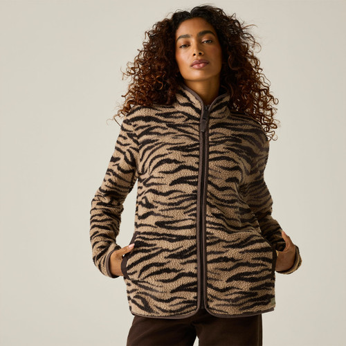 Woman wearing a Regatta women's zebra print borg fleece jacket with full zip fastening, high collar and side pockets.