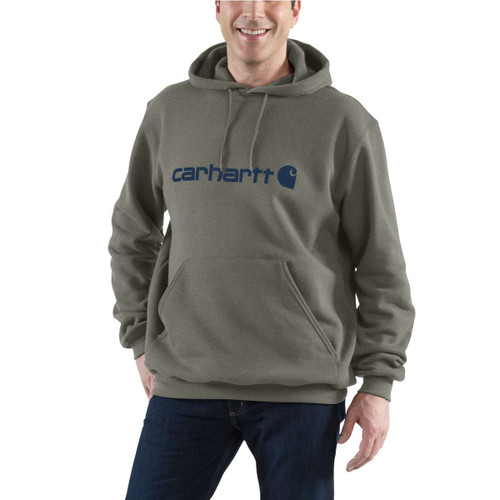 Man modelling a grey-green Carhartt pullover hoodie with navy chest logo, drawstring hood, kangaroo pocket and ribbed cuffs.