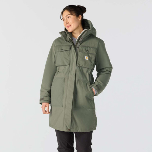 Women’s olive green Carhartt hooded parka worn by a model, featuring four front pockets, a concealed zip fastening and logo patch.