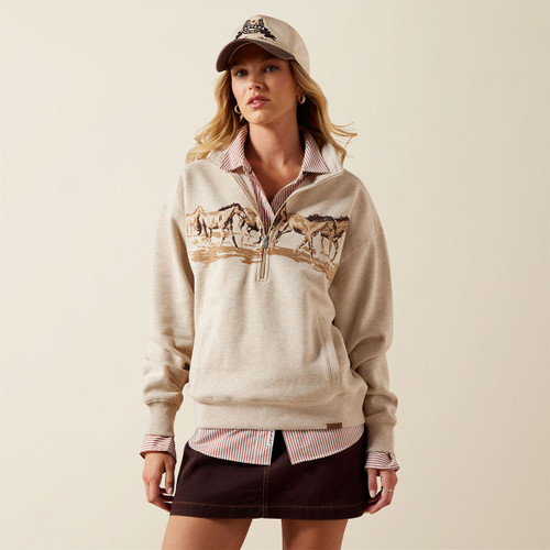 Model wearing a heathered oatmeal quarter-zip sweatshirt featuring a running-horse graphic across the chest, layered over a striped collared shirt.