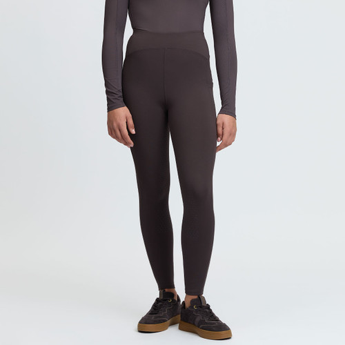 Front view of a model wearing dark brown LeMieux high-waisted riding leggings with subtle full-seat grip detailing.