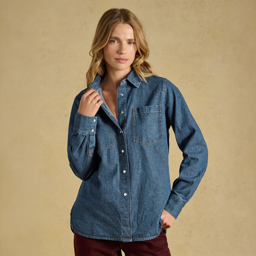 A woman models a slim fit western mid wash denim shirt with a collar and button-up front.
