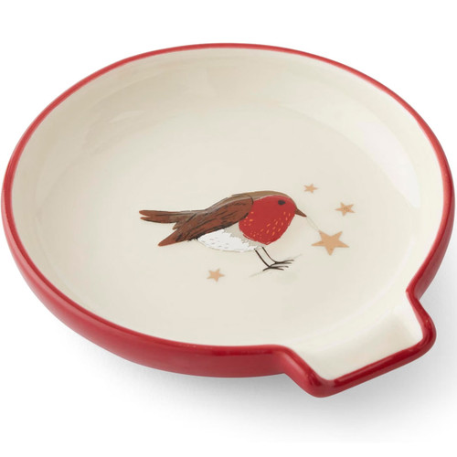 A round ceramic spoon rest with a red rim featuring a painted robin and small stars on a cream background.
