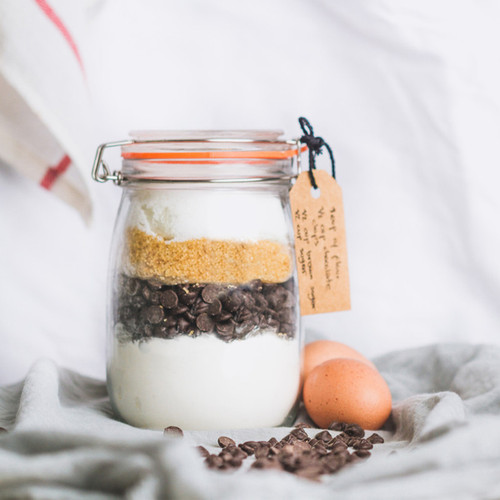 KitchenCraft Home Made 1 litre glass preserving jar filled with baking ingredients, featuring a clip-top lid and airtight orange seal.