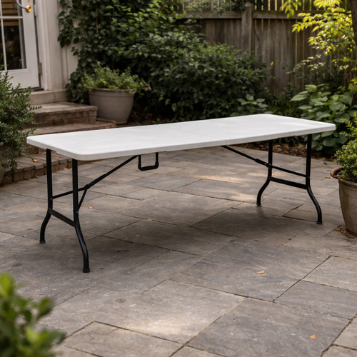 A rectangular folding table with a white plastic top and black metal legs, suitable for events or dining, on a patio.