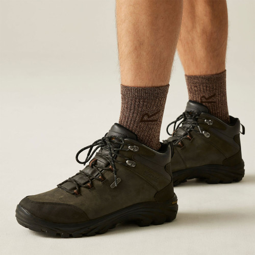 Man wearing dark brown mid-cut hiking boots with lace-up fastening and Vibram soles, paired with brown walking socks. Man wearing dark brown mid-cut hiking boots with lace-up fastening and Vibram soles, paired with brown walking socks.