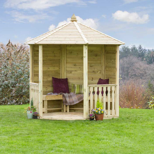 Hexagonal wooden garden gazebo with a pitched roof, open sides and built-in bench seating, positioned on a lawn with cushions and a throw.