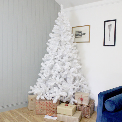 A white Christmas tree with presents underneath in a cosy room décor.