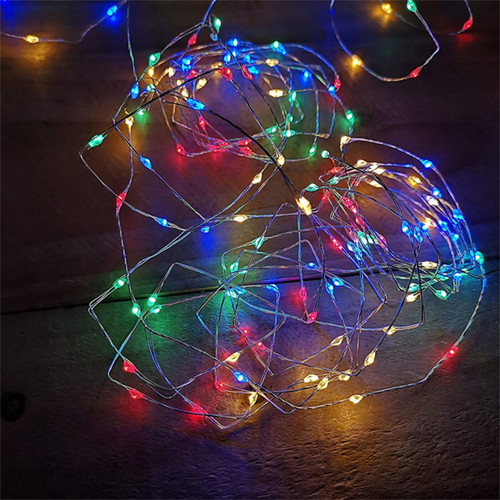 Cluster of Premier 200 Multi-Action LED Battery-Operated Microbrights Multicoloured - 10m on a wooden background