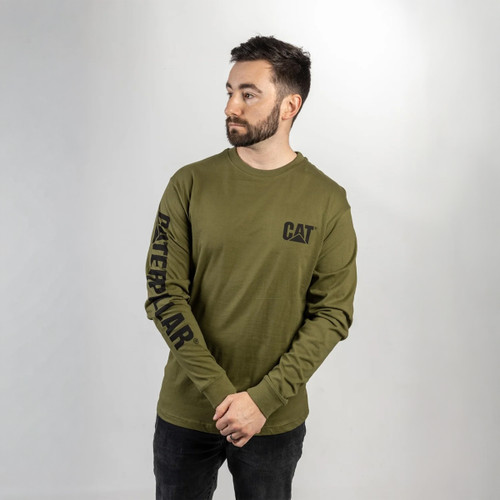 A man with a beard wearing a green long-sleeve shirt with "CAT" on the chest and "Caterpillar" on the sleeve stands against a grey background. A man with a beard wearing a green long-sleeve shirt with "CAT" on the chest and "Caterpillar" on the sleeve stands against a grey background.