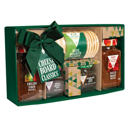 A green gift box features chutney jars, basil cheese biscuits, and caramelized onion chutney, tied with a green bow labelled "Cheese Board Classics."