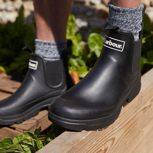 Black Barbour Nimbus Chelsea wellies worn outdoors, showing ankle height design, elastic gussets and rugged sole grip.
