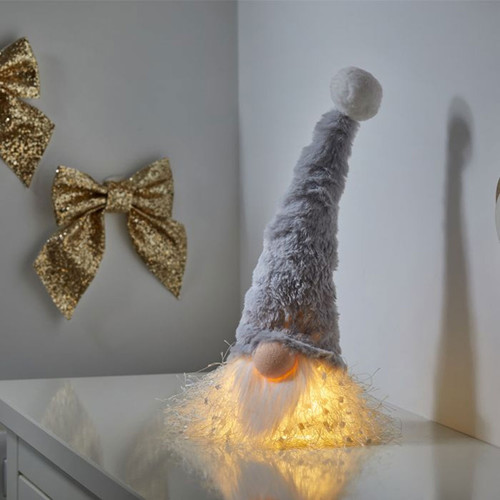 A light up gonk head with a grey hat and white beard on top of a table.