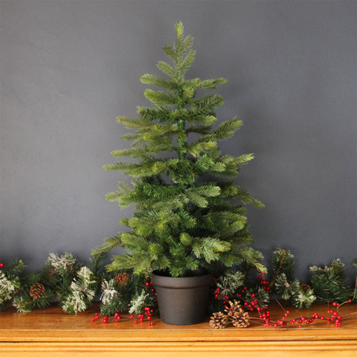 Artificial potted Christmas tree with realistic green pine branches displayed in a black planter, ideal for festive home décor and seasonal indoor displays.