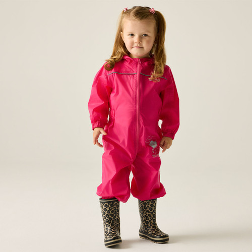 A young child in a bright pink rain suit stands confidently on a neutral background. She wears leopard print boots and has pigtails with pink bows.
